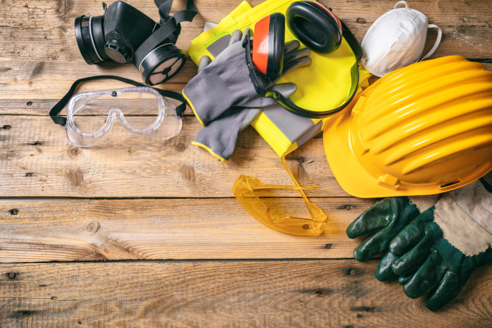 work safety construction site protective equipment on wooden background